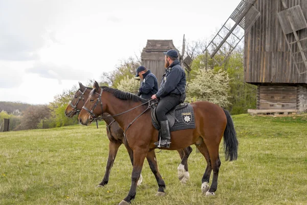 Kyiv, Ukraine - April 23, 2017: Policemen on horseback, a beautiful spring landscape, mounted police, horsemen in the countryside, outdoors. National Museum Pirogovo in the outdoors near Kiev. — Stock Photo, Image