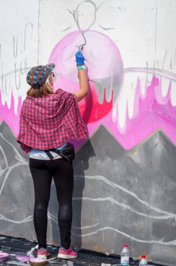 Ukrayna, Nikolaev, 24.06.2017: Festival grafiti gençlik günlük ayrılmış. Şehir merkezi kare. Genç kız bir sprey ile grafiti çizer.