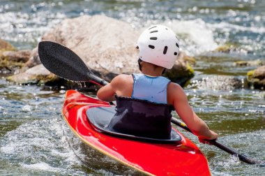 Bir genç Kayak sanatı eğitiyor. Kaba river rapids üzerinde tekne tekneler. Çocuk ustaca rafting içinde devreye girer.