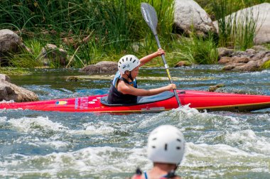 Köy, Mihia, Ukrayna - 9 Temmuz 2017. Bir genç Kayak sanatı eğitiyor. Tedavi edilmemiş river rapids üzerinde tekne tekneler. Ustaca ebeveyn kontrolü altında rafting yapan çocuk.
