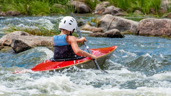 Un adolescente entrena en el arte del kayak. Barcas en rápidos de río. El niño se dedica hábilmente al rafting. . —  Fotos de Stock