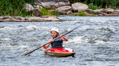 Köy Myhia, Mykolayiv bölgesi, Güney Bug Nehri, Ukrayna - 9 Temmuz 2017: bir genç trenler Kayak sanatı. Kaba river rapids üzerinde tekne tekneler. Çocuk ustaca rafting içinde devreye girer.