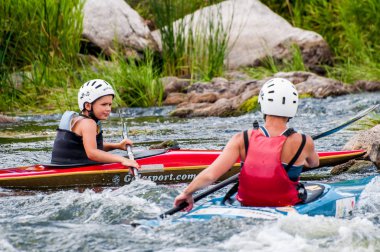 Köy, Mihia, Ukrayna - 9 Temmuz 2017. Bir genç Kayak sanatı eğitiyor. Tedavi edilmemiş river rapids üzerinde tekne tekneler. Ustaca ebeveyn kontrolü altında rafting yapan çocuk.