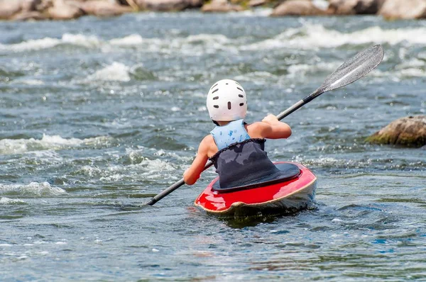 V pubertě vlaky v umění jízdy na kajaku. Slalomky na hrubý říční peřeje. Dítě se obratně zabývá rafting. — Stock fotografie