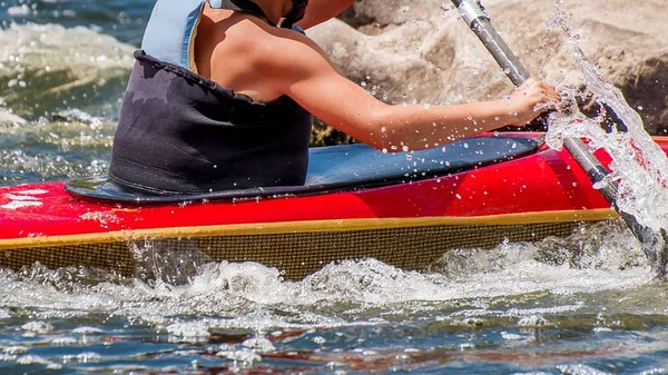 A teenager trains in the art of kayaking. Slalom boats on rough river rapids. The child is skillfully engaged in rafting. — Stock Photo, Image