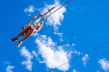 Ukrayna, Migea - 30 Haziran 2017: Zipline. Bir adam güzel bir mavi gökyüzü beyaz bulutlar ile karşı çelik kablo üzerinde kayar bir görüntü. Aşırı ve aktif dinlenme.