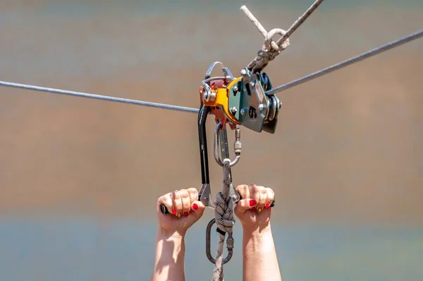 Zipline. Güvenli çelik kablo üzerinde sürme için ekipman. Uçuş sırasında kadının elleri yakın çekim. — Stok fotoğraf