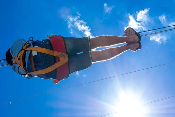Zipline。一个人对美丽的蓝天与白云钢电缆上滑动一个视图。极端和积极的休息. — 图库照片