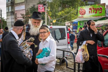 Uman, Ukrayna - 2 Ekim 2016: Rosh Hashanah, Yahudi yeni yılı 5777. Haham Nachman Uman içinde mezar yakınındaki kutladı. Toplu tatil sırasında Hasid Hacı dini edebiyat satıyor..