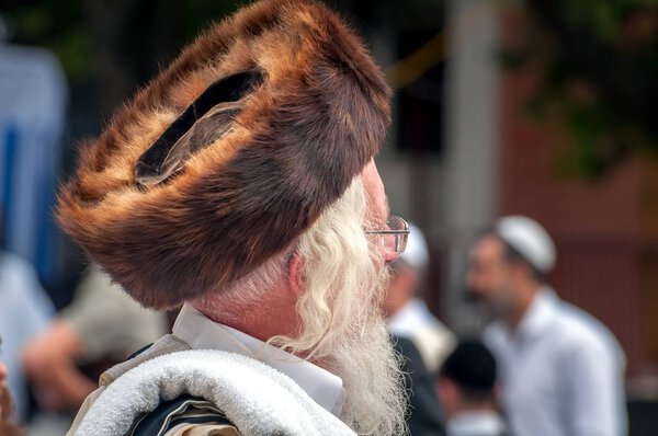 Hasid in the traditional headgear shtreimel on the street in a crowd of pilgrims. Uman, Ukraine - 21 September 2017: Rosh Hashanah, Jewish New Year