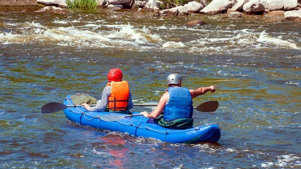 Rafting, kayak. Dos atletas en equipo deportivo están navegando en un barco inflable de goma. Trabajo en equipo . — Foto de Stock