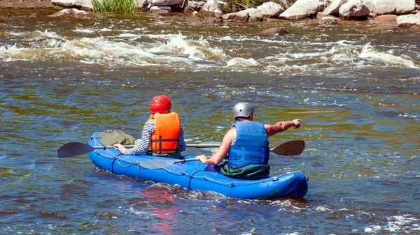 Rafting, καγιάκ. Δύο αθλητές σε αθλητικό εξοπλισμό πλέουν σε ένα φουσκωτό σκάφος από καουτσούκ. Ομαδική εργασία. — Φωτογραφία Αρχείου