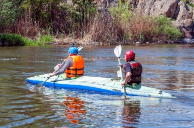Myhiya, Ukrayna - 1 Mayıs 2018: Rafting ve Kano. İki sporcu spor malzemeleri bir lastik şişme tekne yelken. Ekip çalışması. Aşırı spor. Ekolojik su turizm.