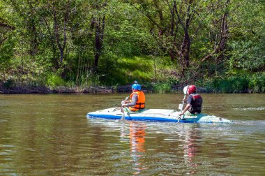 Myhiya, Ukrayna - 1 Mayıs 2018: Rafting ve Kano. İki sporcu spor malzemeleri bir lastik şişme tekne yelken. Ekip çalışması. Aşırı spor. Ekolojik su turizm.