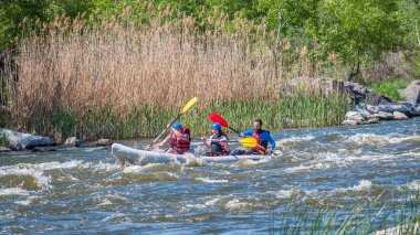 Myhiya, Ukrayna - 1 Mayıs 2018: Rafting ve Kano. Üç sporcular bir lastik şişme tekne yelken. Ekip çalışması. Su sıçramalarına yakın çekim. Aşırı spor. Ekolojik su turizm.