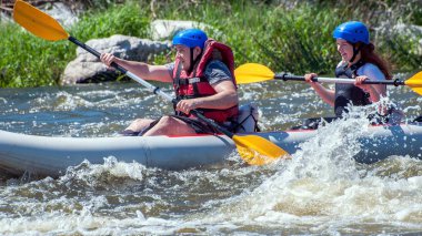 Myhiya, Ukrayna - 1 Mayıs 2018: Rafting ve Kano. İki sporcu kaynar su akışı bir lastik şişme botla yelken. Su sıçramalarına yakın çekim. Aşırı spor. Ekolojik su turizm.