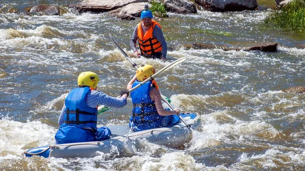 Myhiya, Ucrânia - 1 de maio de 2018: Rafting e caiaque. Dois desportistas estão navegando em um barco inflável de borracha em uma corrente de água fervente. A água espirra de perto. Desporto extremo. Turismo ecológico da água . — Fotografia de Stock