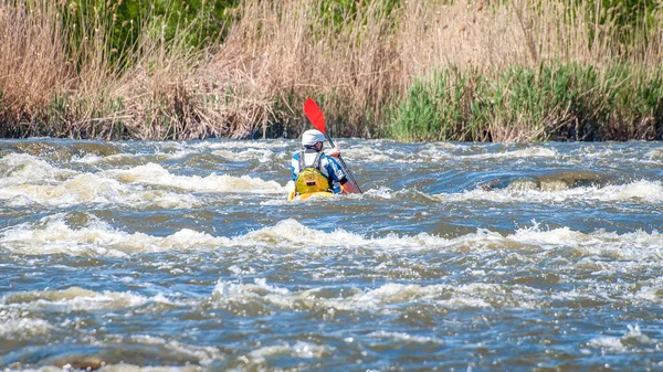 A man in a small kayak in a stormy stream of water. Rafting, kayaking. Extreme sport. Water ecological tourism