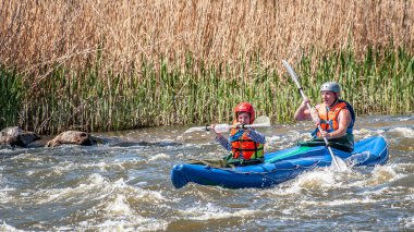 Myhiya, Ukrayna - 1 Mayıs 2018: Rafting, Kayak. Genç çift Yelkenli su fırtınalı bir akıştaki bir lastik şişme teknede evlendi. Su sıçramalarına yakın çekim. Ekolojik su turizm.