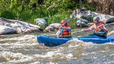 Myhiya, Ukrayna - 1 Mayıs 2018: Rafting, Kayak. Genç çift Yelkenli su fırtınalı bir akıştaki bir lastik şişme teknede evlendi. Su sıçramalarına yakın çekim. Ekolojik su turizm.