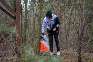 Katerynka, Ukrayna - 13 Aralık 2019: Orienteering. Geleneksel geleneksel oyun. Genç sporcu kontrol noktasının geçişini işaretliyor..