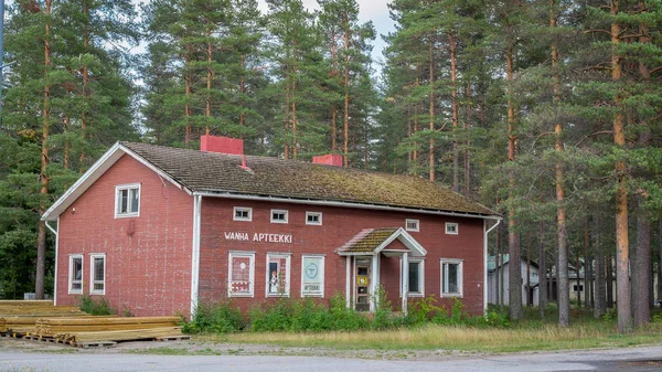 Finlândia, Hyrynsalmi, região de Kainuu - 27 de agosto de 2018: Antigo edifício autêntico de farmácia de madeira vintage. A fachada é forrada com tábuas de madeira vermelha . — Fotografia de Stock