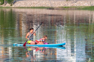 Finland - August 1, 2018. Ukkohalla Ski Resort is located in Central Finland. In summer, water sports and recreation are practiced on the lake. Mom with a child in a rubber boat.
