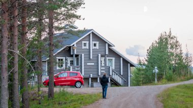 Finland - August 19, 2018. Ukkohalla Ski Resort is located in Central Finland. A cozy picturesque cottage in the middle of an ecologically clean coniferous forest. A red car is parked near the house.