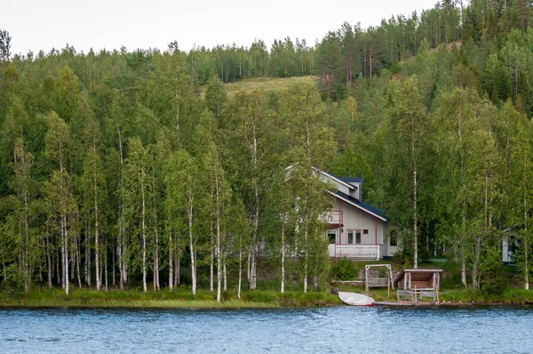 Finlândia - 19 de agosto de 2018. Ukkohalla Ski Resort está localizado na Finlândia Central, a região de Kainuu. O ar mais amigo do ambiente. Um lago no meio de uma floresta. Casas pitorescas acolhedoras . — Fotografia de Stock