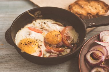 Sebzeli sahanda yumurta, ahşap arka planda salata. Üst manzara, fotokopi alanı, kırsal sağlıklı yiyecek kavramı.
