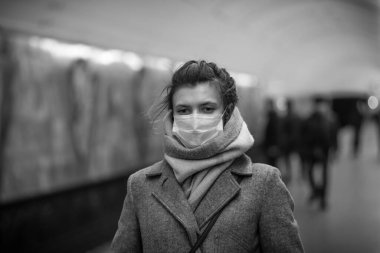 Metroda grip virüslerine ve koronavirüs COVID-19 'a karşı koruyucu maskeli çekici Avrupalı bir kadın var.