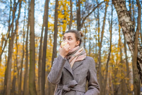 Jeune Femme Attrayante Manteau Mange Une Pomme Savoureuse Dans Parc — Photo