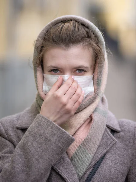 Young woman in a protective mask against viruses on the street