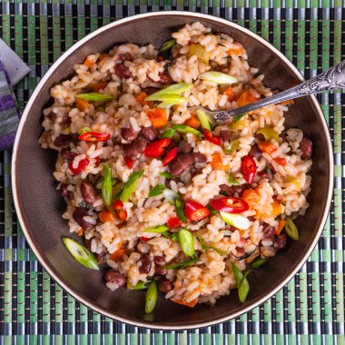 Geleneksel Jamaika ve Meksika yemekleri. Fasulye ve sebzeli pirinç ve bambu peçetesinde sıcak biber.