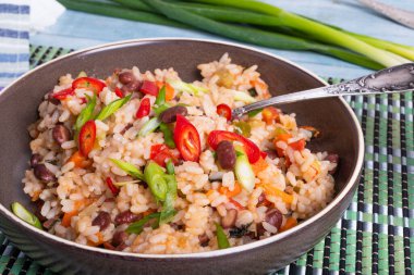 Geleneksel Jamaika ve Meksika yemekleri - fasulye ve sebzeli pilav bambu peçetesinde, lezzetli vejetaryen yemeği