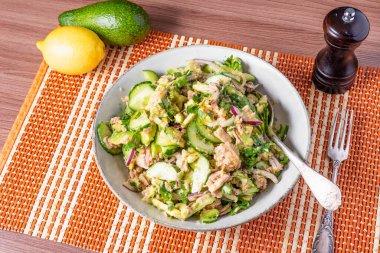 Sağlıklı ton balığı, avokado ve soğanlı salatalık. Masada malzemelerle birlikte. Amerikan mutfağı.