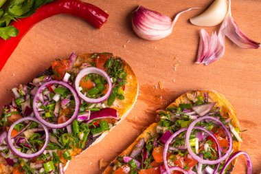 Doğranmış domatesli İtalyan sebzeli bruschetta, kırmızı biber, taze soğan, kırmızı soğan, otlar ve kesme tahtasındaki zeytinyağı.