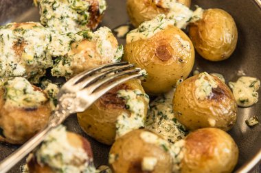 İsveç yemekleri. Krema soslu geleneksel tavuk köfteleri ve ahşap arka planda yeni patatesler.