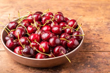 Kırsal ahşap bir masada kırmızı kiraz meyveleri.