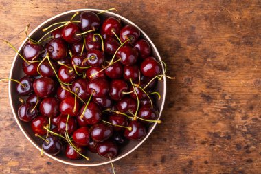 Kırmızı kirazlı, kirazlı meyveler kırsal ahşap bir masada, yakın plan, kopyalama alanı