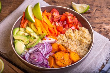 Kinoalı salata kasesi; havuç; avokado; soğan; biber; limon dilimli domates - vejetaryen yemeği; Buda kasesi