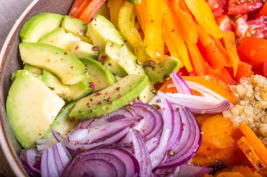 Kinoalı salata kasesi; havuç; avokado; soğan; biber; limon dilimli domates - vejetaryen yemeği; Buda kasesi