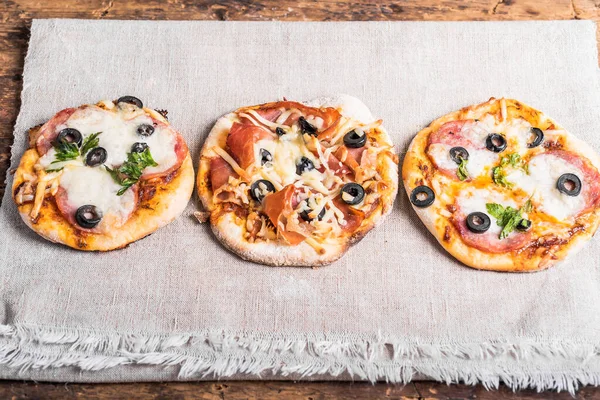 Kilka Gotowych Mini Pizzy Pizzetta Kiełbasą Bekonem Jamon Lnianej Serwetce — Zdjęcie stockowe