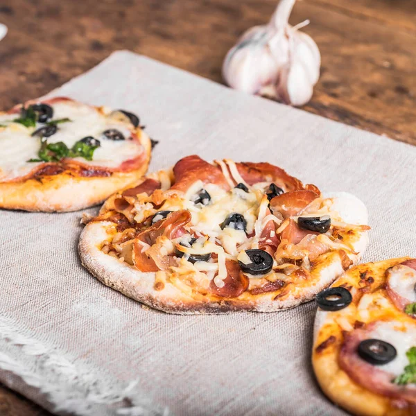Kilka Gotowych Mini Pizzy Pizzetta Lnianej Serwetce Drewnianym Stole — Zdjęcie stockowe