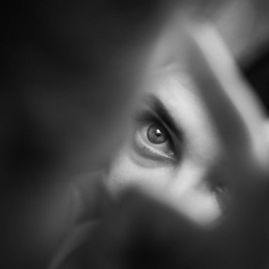 Sabah makyaj evi. Genç bir kadının yüzü ve gözlerinden bir parça siyah bir aynaya yansıyor.