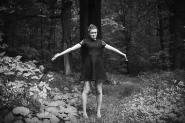 Karanlık bir ormanda çekici, neşeli bir genç kadın.