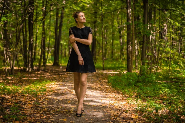 Όμορφη Νεαρή Γυναίκα Ένα Μαύρο Φόρεμα Ένα Μονοπάτι Ένα Φθινόπωρο — Φωτογραφία Αρχείου