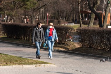 Moskova, Rusya, 28 Mart 2020 - Parkta maskeli genç bir çift covid-19 'dan korunuyor. Moskova 'daki koronavirüs salgınının başlangıcı..