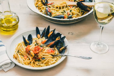 İtalyan sağlıklı deniz ürünleri, midyeli makarna ve bir bardak beyaz şarap.