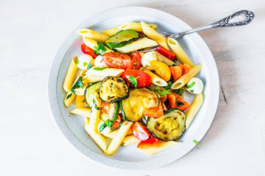 Tabak manzaralı Margarita makarna - domatesli makarna, kabak, mozzarella ve fesleğen.